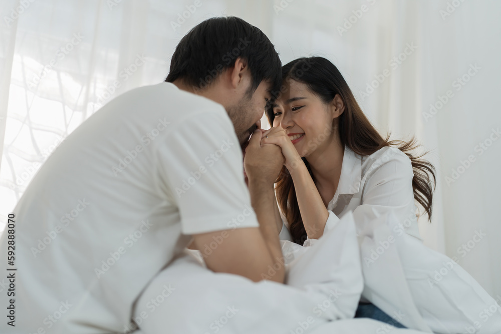 Asian Romantic couple in bed enjoying sensual foreplay Happy sensual young couple lying in bed together. Beautiful loving couple kissing in bed. Asian Romantic couple in bed enjoying sensual foreplay Happy sensual young couple lying in bed together. Beautiful loving couple kissing in bed.