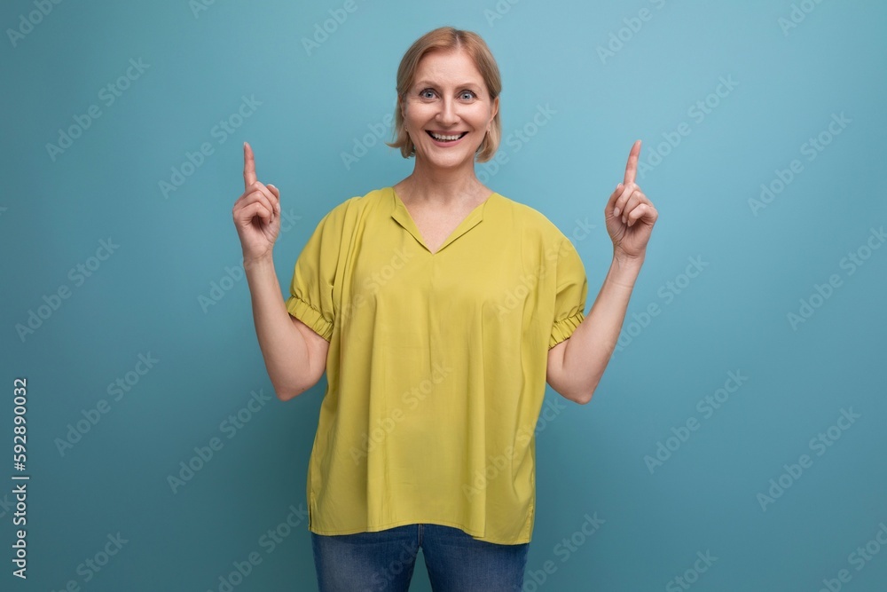 energetic blond mature woman in yellow tank top shows like with hands energetic blond mature woman in yellow tank top shows like with hands