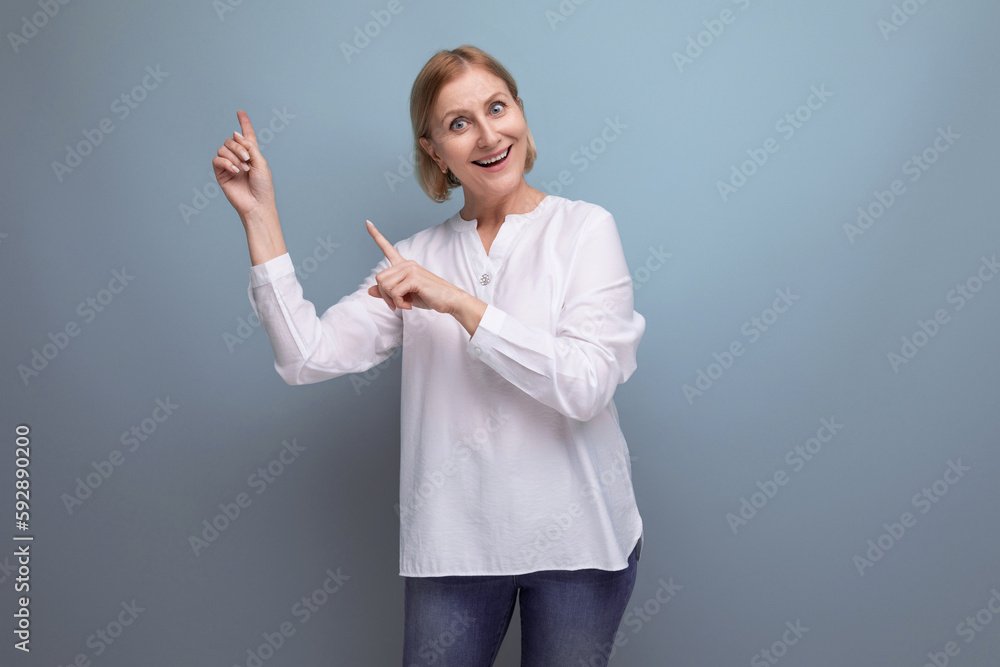 well-groomed slender blond mature woman smiles cheerfully on a studio background well-groomed slender blond mature woman smiles cheerfully on a studio background