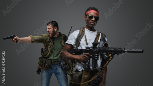 Studio shot of black macho man and violent man survivors in post apocalyptic setting.
