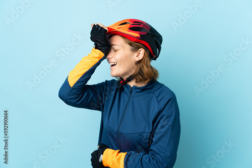 Young cyclist woman isolated on blue background has realized something and intending the solution