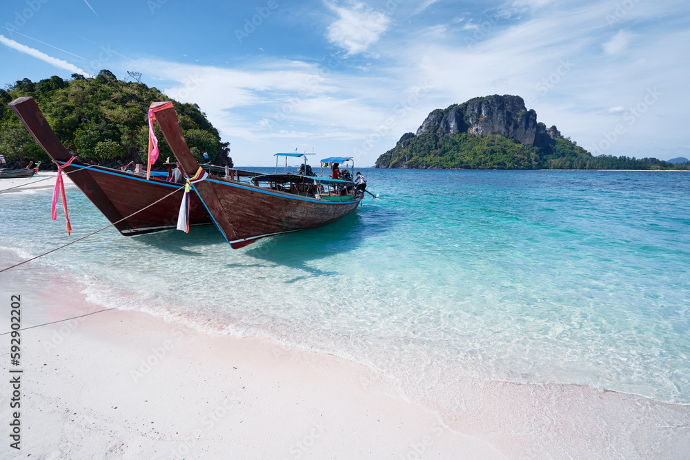 Beautiful landscape with traditional longtail boats, rocks, cliffs, tropical white sand beach. Traveling by Thailand.