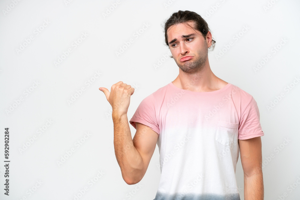 Caucasian handsome man isolated on white background unhappy and pointing to the side Caucasian handsome man isolated on white background unhappy and pointing to the side