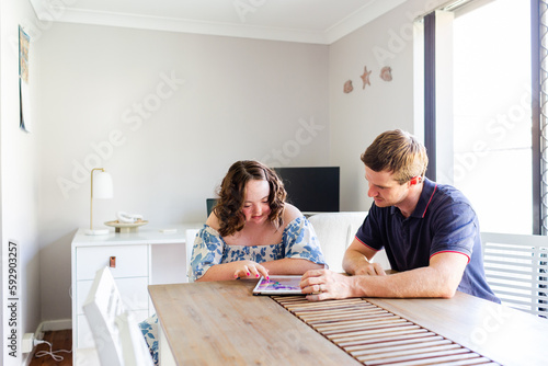 Teen having discussion with adult occupational therapist worker while using ipad device