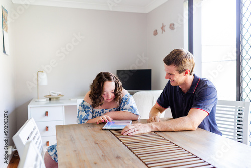 Teen having discussion with adult occupational therapist worker while using ipad device photo