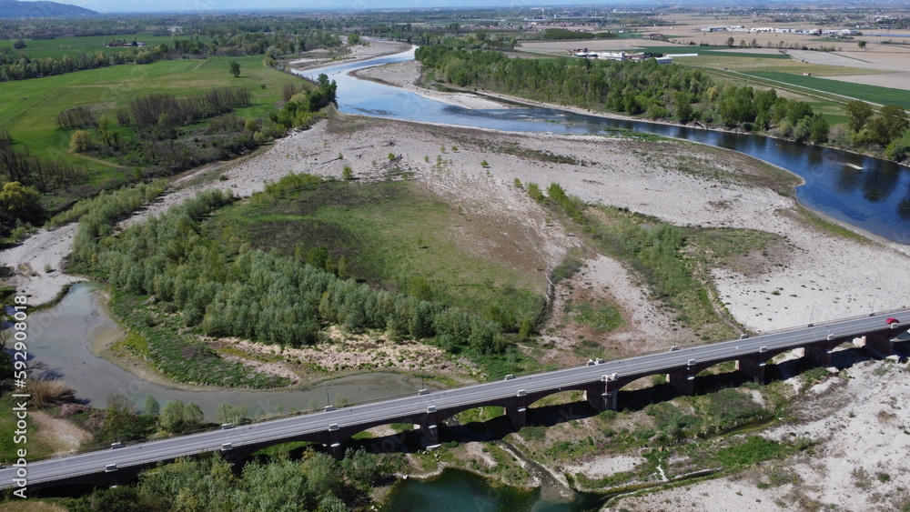 The drone flies over the Roman bridge with cars and trucks above and below The river dried up by drought with its course has now become an island of sand - Video 4k 02