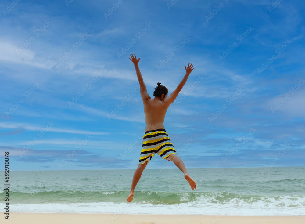 Young man tourrist feeling happiness and freedom mood with jumping on beach background Young man tourrist feeling happiness and freedom mood with jumping on beach background