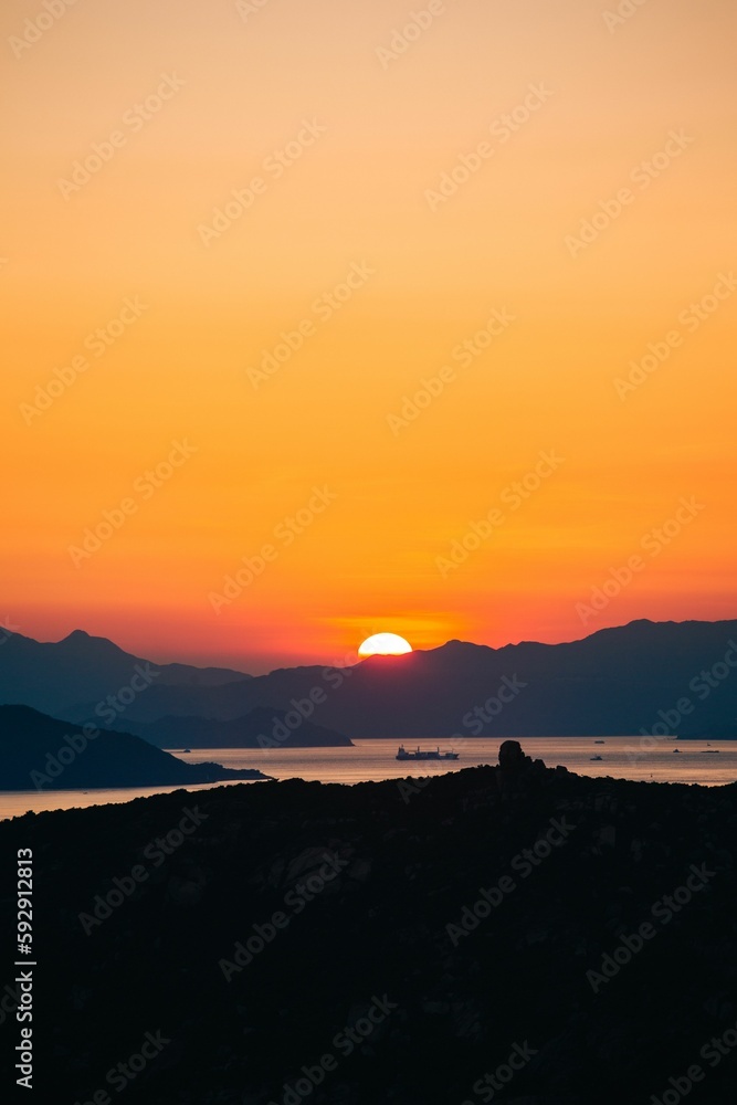 Sunset behind Lantau Island with cargo boats in the foreground