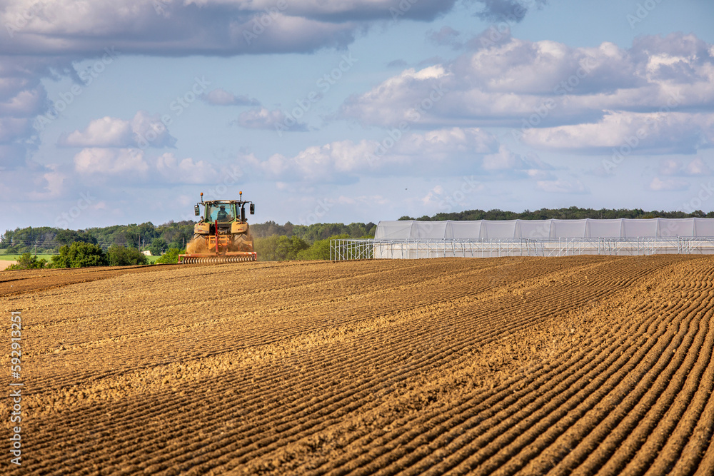 Fototapeta premium Tracteur au travail dans les champs au printemps.