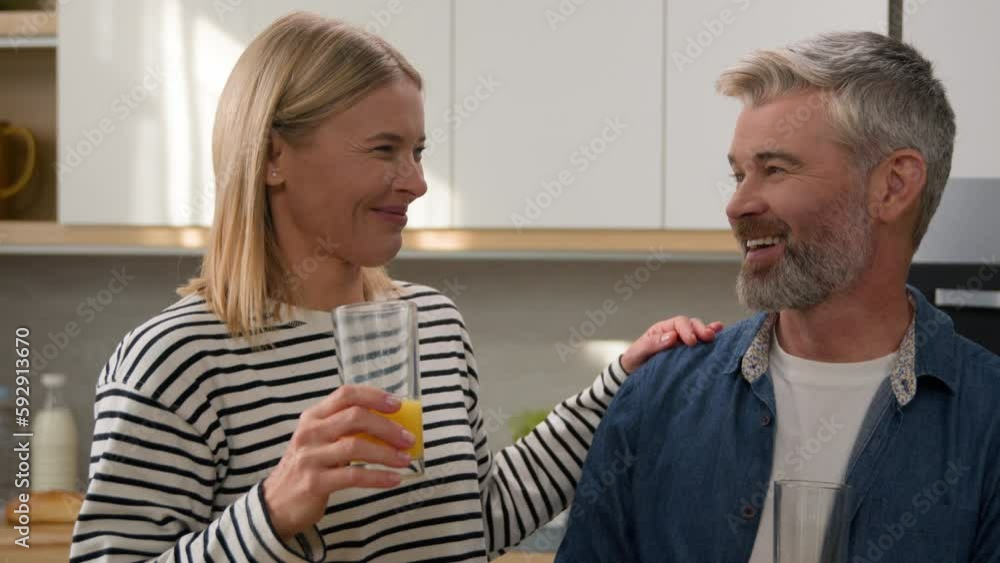 Happy couple family Caucasian adult woman and mature man middle-aged husband and wife drinking orange juice in home kitchen laughing enjoy tasty healthy fruit fresh drink laugh smiling diet healthcare Happy couple family Caucasian adult woman and mature man middle-aged husband and wife drinking orange juice in home kitchen laughing enjoy tasty healthy fruit fresh drink laugh smiling diet healthcare