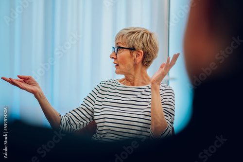 Senior woman psychologist on a group therapy session discussing mental health issues