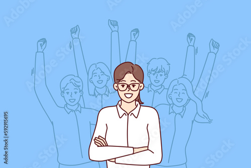 Woman leader standing with arms crossed near team located behind and making victorious wave of hands. Businesswoman leader or company manager posing for advertising banner of consulting corporation