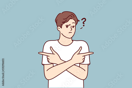 Puzzled man pointing fingers in different directions doubtful trying to accept difficult decision with unknown consequences. Puzzled guy is wondering what to make choice between two options 