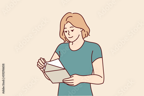 Woman with envelope in hands reads letter received in mail with invitation to entertainment event or conference. Girl with notice from bank in postal envelope demanding payment of interest on loan 