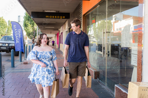 Young NDIS provider disability worker walking with girl with a disability shopping together photo