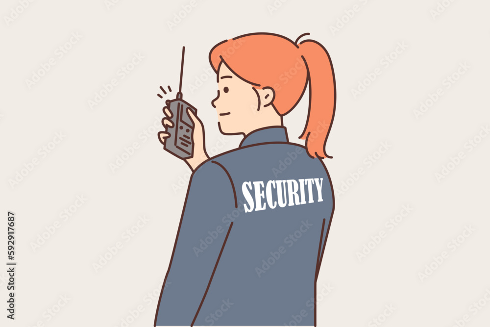 Woman security guard uses walkie-talkie to contact colleagues or report intruder Woman security guard uses walkie-talkie to contact colleagues or report intruder