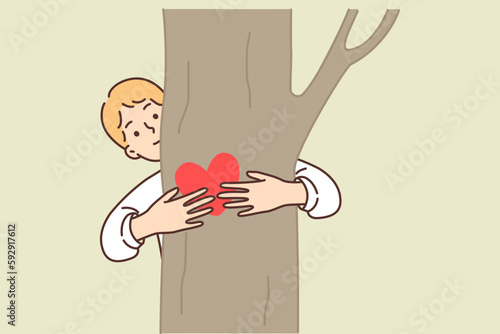 Teenage boy hugging tree is sign of love for ecology and concern for environment
