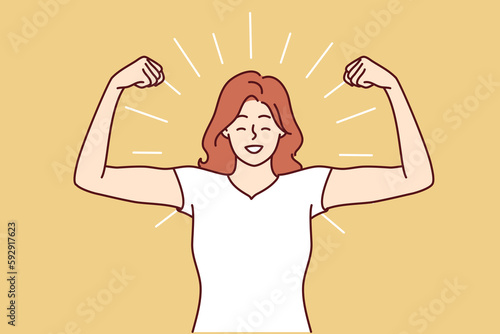 Woman shows biceps and smiles standing in strongman pose to demonstrate self-confidence and readiness for new achievements. Girl boasts biceps after going to fitness room and training with trainer 