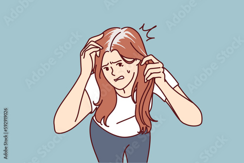 Worried woman with gray hair is nervous due to premature baldness associated with lack of nutrients and calcium. Girl needs trip to dermatologist due to appearance of gray hair or dandruff 