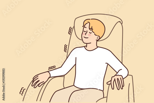 Man relaxed sitting in massage chair enjoying comfort and wellness treatments for spine and muscles