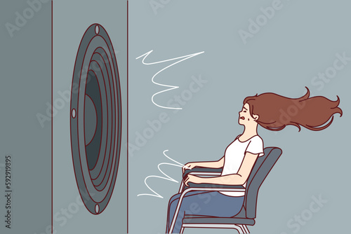 Deafened woman near giant subwoofer from music center listening to loud rhythmic track with bass sitting in chair. Subwoofer with round speaker produces loud sound waves for girl who loves rock songs 