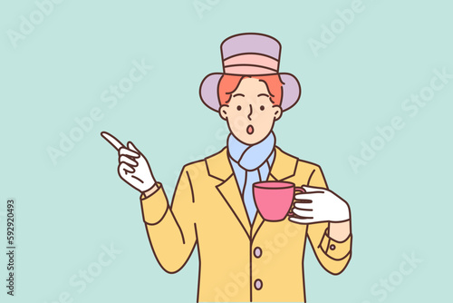 Mysterious man dressed as hatter from story Alice in Wonderland drinks tea and points finger to side