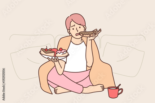 Sad woman eats lot of sweet high-calorie food wanting to get rid of stress after failed relationship