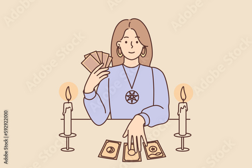 Woman with Tarot cards in form of witch sits at table and predicts future being fortune teller 