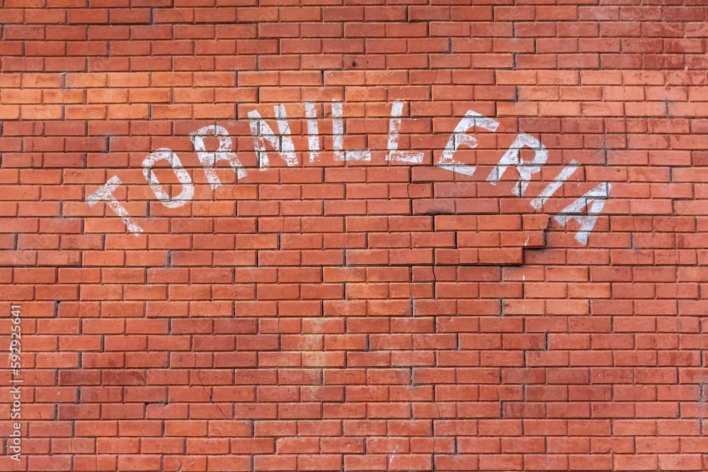 Brick wall background with Tornilleria text Brick wall background with Tornilleria text