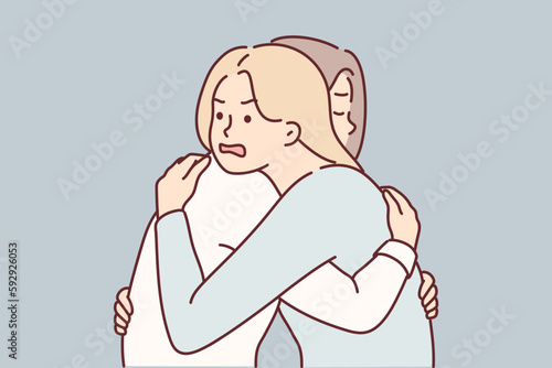 Woman with angry expression hugs girl friend hiding envy or jealousy in order to deceive