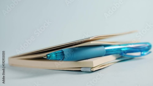 Closeup of a person putting down a sketchbook with a blue pen inside it