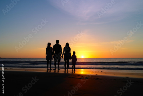 Silueta a contraluz de familia en la playa viendo el atardecer mirando al horizonte. Generative ai. © ACG Visual