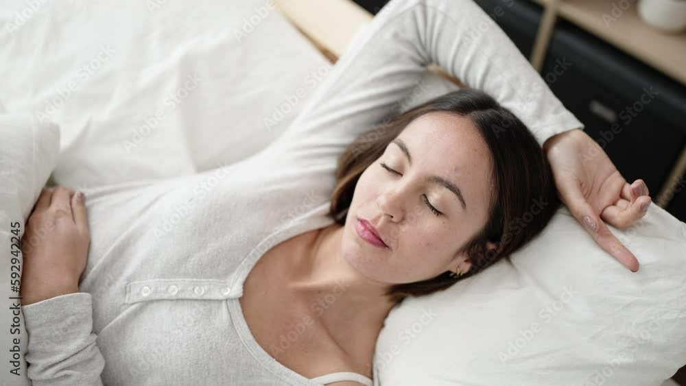 Young beautiful hispanic woman lying on bed sleeping at bedroom Young beautiful hispanic woman lying on bed sleeping at bedroom