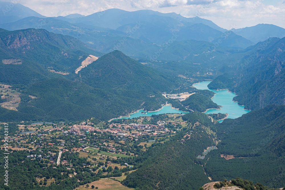 Aerial scenic view of the tree-covered mountain slopes and the river in a valley