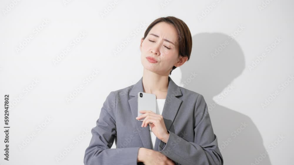 スマートフォンを持ちながら考え込んでいる若い女性　ビジネスイメージ	
