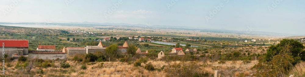 Panoramic shot of the Dalmatian landscape from a hill against a blue sky
