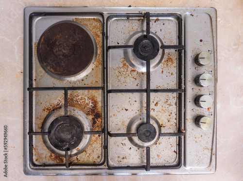 Dirty gas stove in the kitchen, top view. Gas stove with food remnants.