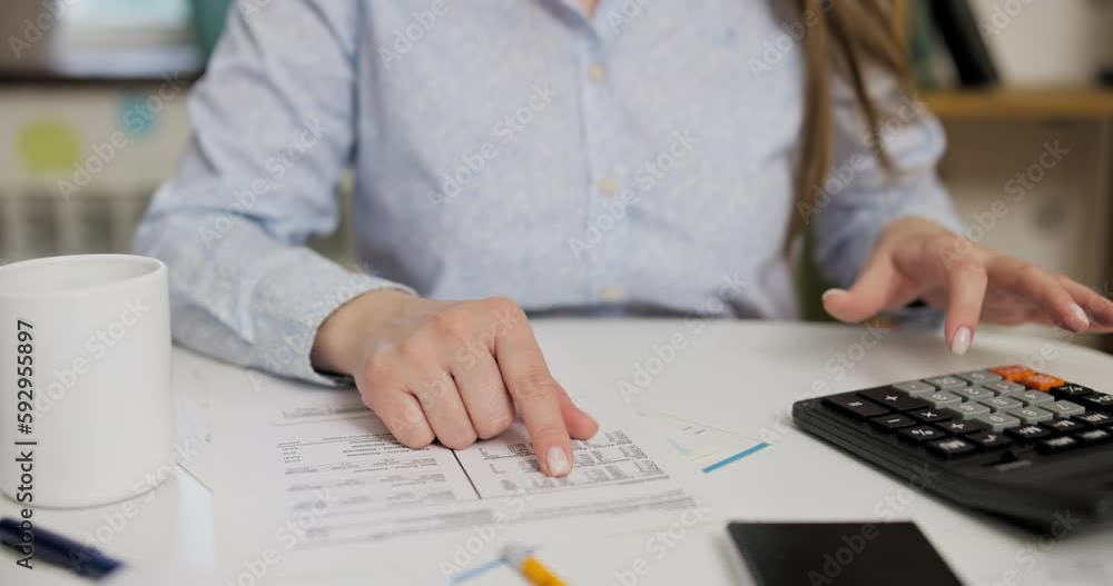 Woman using calculator for calculate domestic bills at home Woman using calculator for calculate domestic bills at home