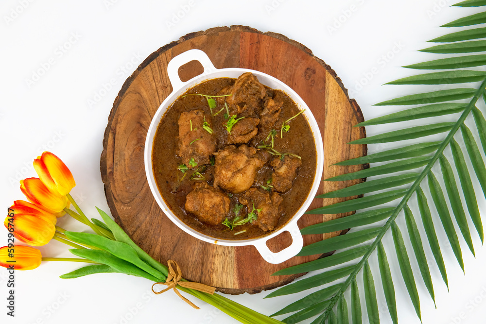Chicken curry or masala or country chicken kuzhambu Tamilnadu style , chicken curry using fried coconut oil in traditional way and decorated in white bowl. Main dish for rice, chapati and paratha...