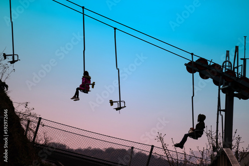 Chairlift - people silhouettes with morning sky on background