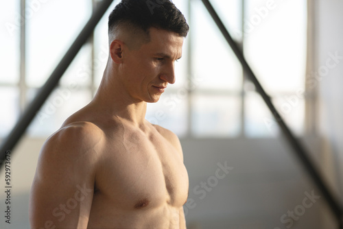 Serious hispanic muscular man, athlete, indoors. Healthy lifestyle concept, copy space