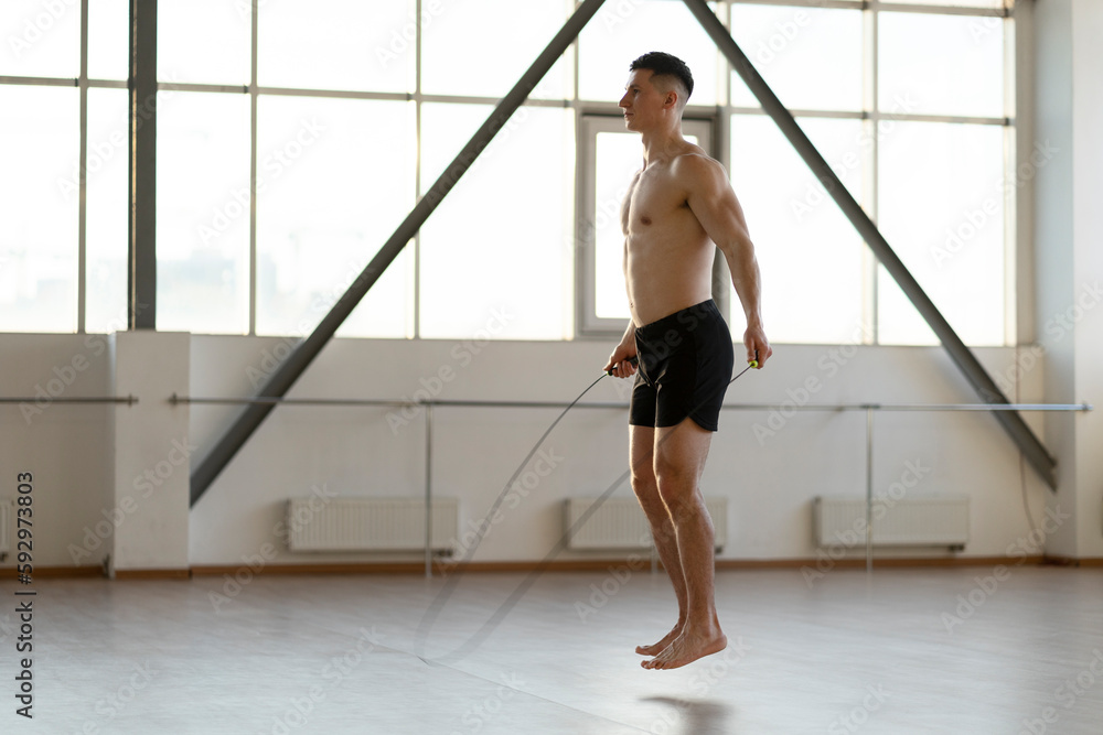 Attractive hispanic man with naked torso doing exercises with skipping rope. Concept of healthy life Attractive hispanic man with naked torso doing exercises with skipping rope. Concept of healthy life