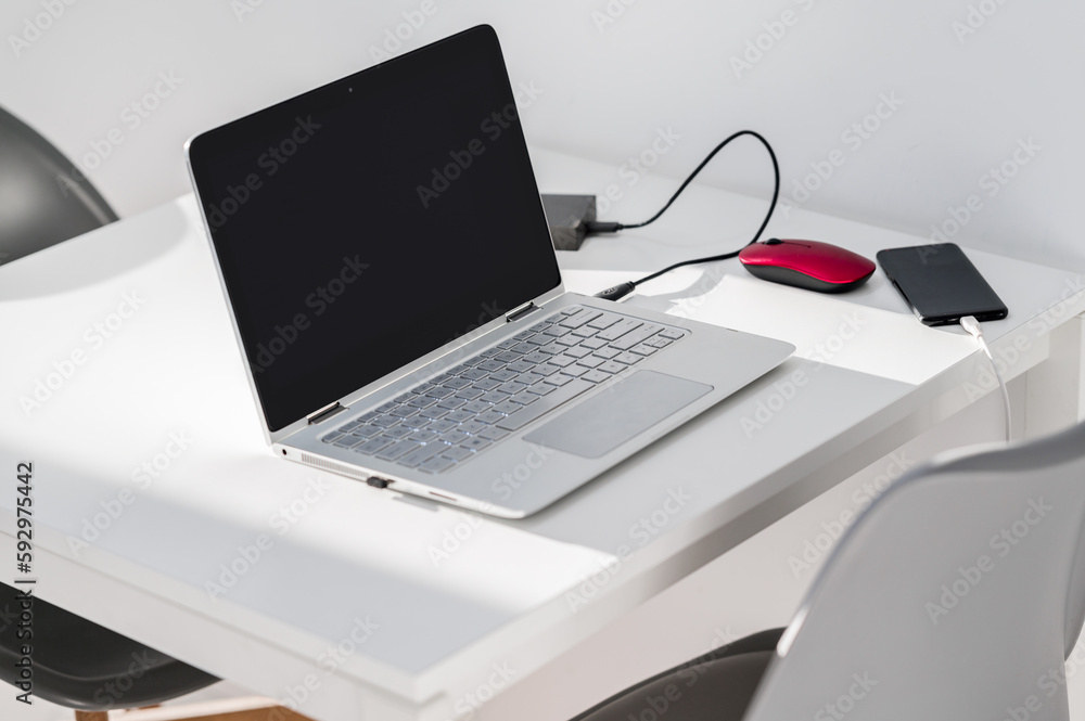 Working remote a section of a table with a laptop with a hard drive ...