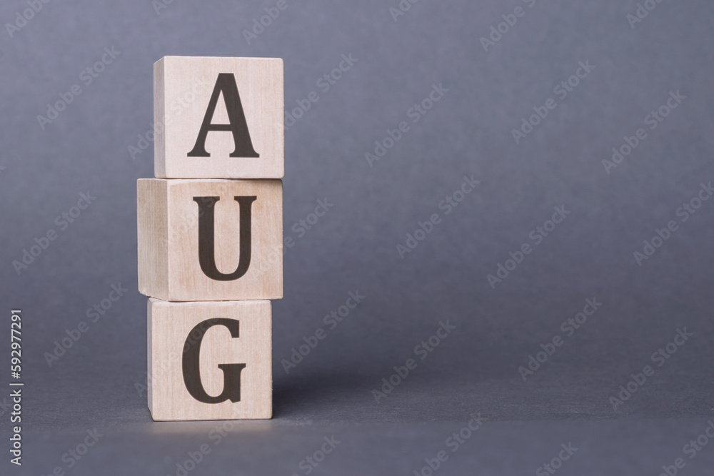 AUG text made of wooden cube on gray background. AUG text made of wooden cube on gray background.