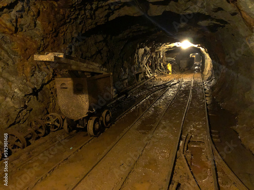 Underground gold mine with carts, tracks and tunnels.