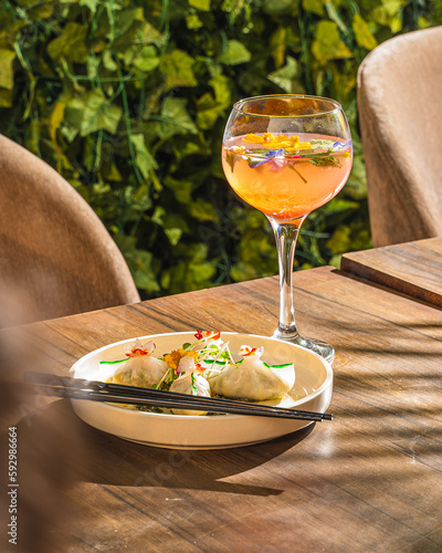 food on the table dim sums and a mocktail cocktail with chopsticks