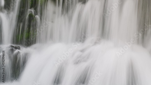 Closeup of big foamy waterfall stream splashing down