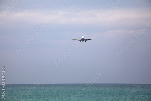 A large plane lands over the sea and the beach. Beach near the airport. A beautiful plane.