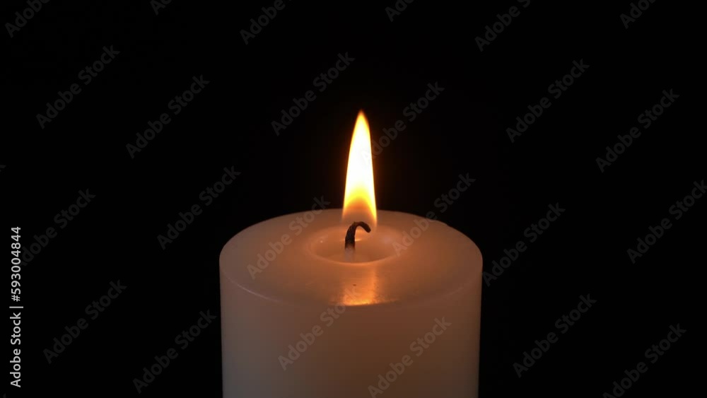 Match lights a large white round candle in total darkness Match lights a large white round candle in total darkness