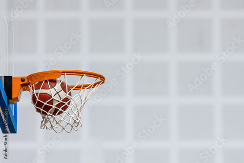 Basketball Ball On Wooden Sports Court. Junior Level Basketball Players Playing Game in Blurred Background. Basketball Training Background. © lightpoet